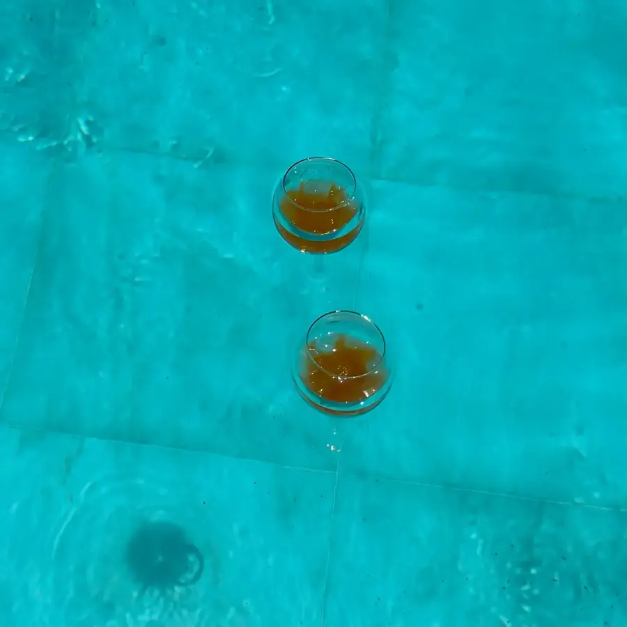 Zwei Gläser Aperol Spritz treiben im Pool